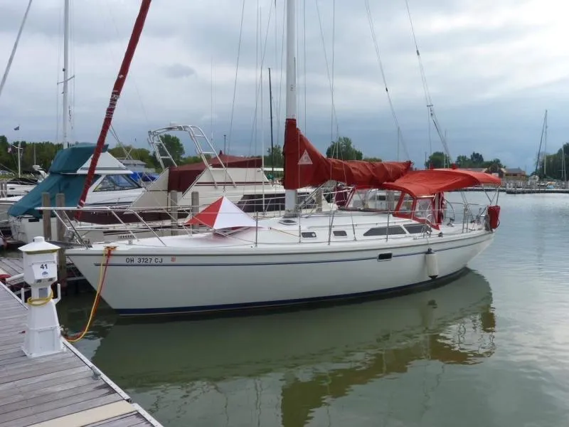 The Image of 1999 Catalina 36 Mark II sailboat docked at a marina with red sail covers. - 1