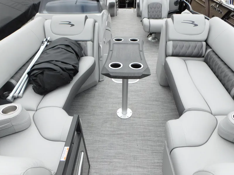 Slide: The Image of 2023 Bennington 24 LXSFBA pontoon boat interior with gray seating and table. - 3