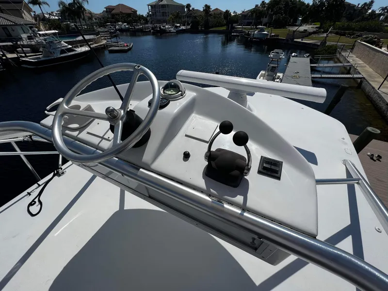 Slide: The Image of 2003 Ocean 40 Super Sport yacht helm with steering wheel and controls, docked in a marina. - 27