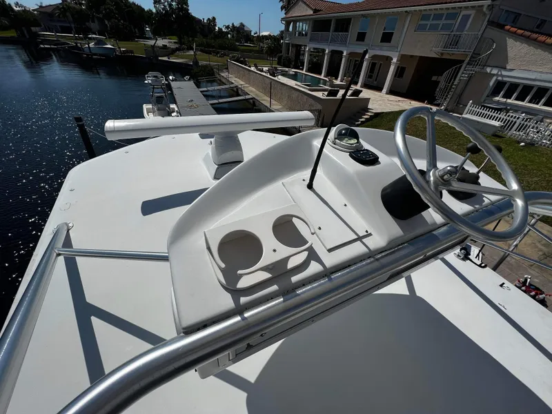 Slide: The Image of 2003 Ocean 40 Super Sport boat helm with steering wheel and cup holders. - 29