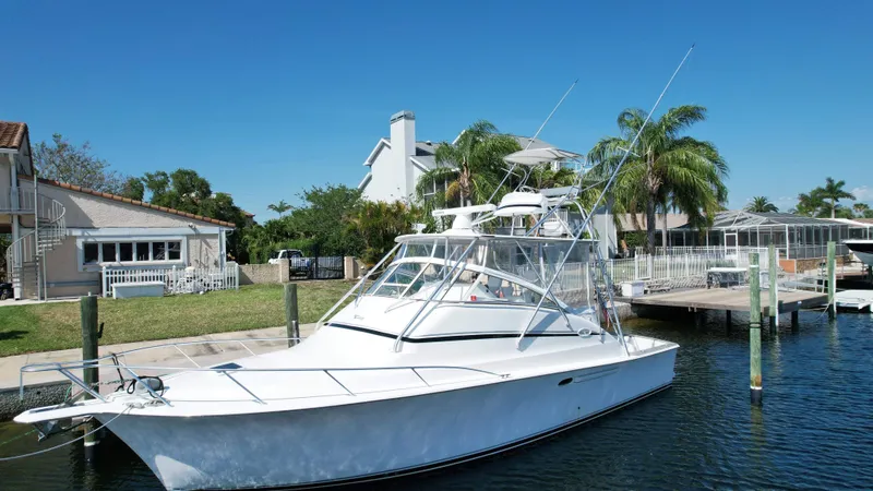 Slide: The Image of 2003 Ocean 40 Super Sport yacht docked by waterfront homes, clear blue sky. - 3