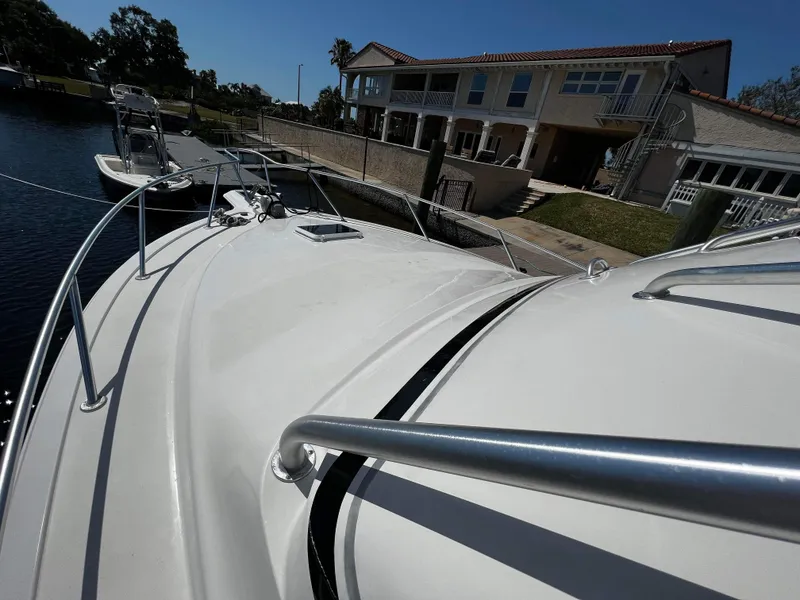 Slide: The Image of 2003 Ocean 40 Super Sport yacht docked near waterfront house under clear blue sky. - 45