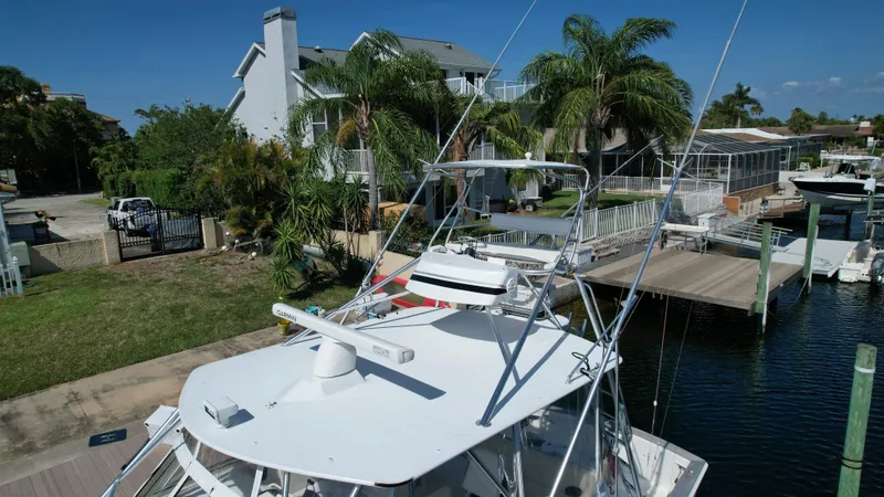 Slide: The Image of 2003 Ocean 40 Super Sport yacht docked near waterfront homes with palm trees. - 7