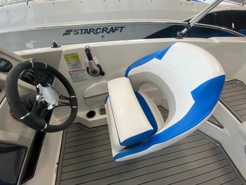 Slide: The Image of 2024 Starcraft SVX 211 boat interior with steering wheel and blue-white captain's chair. - 11