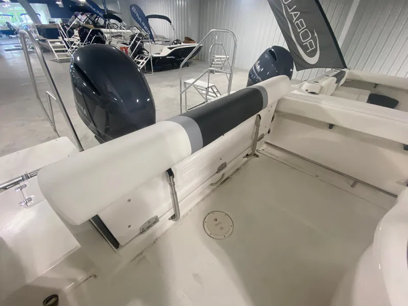 Slide: The Image of 2024 Robalo R222 boat interior with dual outboard motors in showroom. - 4
