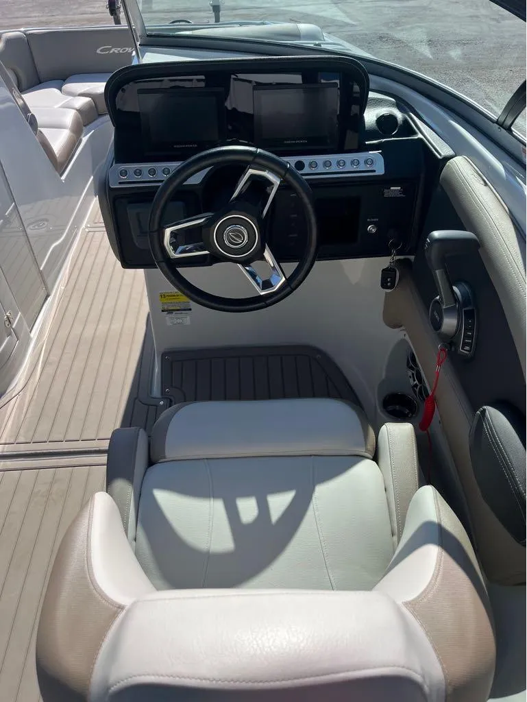Slide: The Image of 2023 Crownline E255 Surf boat cockpit with steering wheel and dashboard controls. - 3