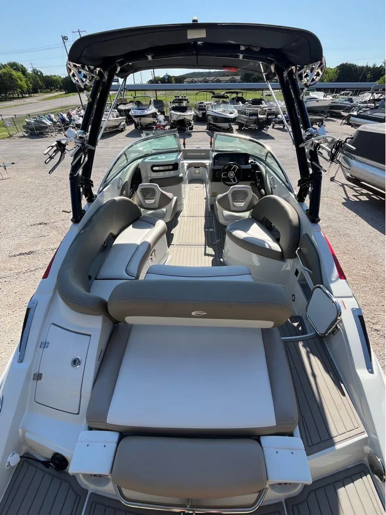 Slide: The Image of 2023 Crownline E255 Surf boat interior with seating and helm, displayed outdoors. - 5