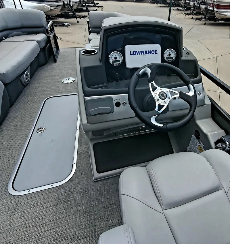 Slide: The Image of 2023 Regency 230 DL3 boat interior with steering console and Lowrance navigation system. - 3