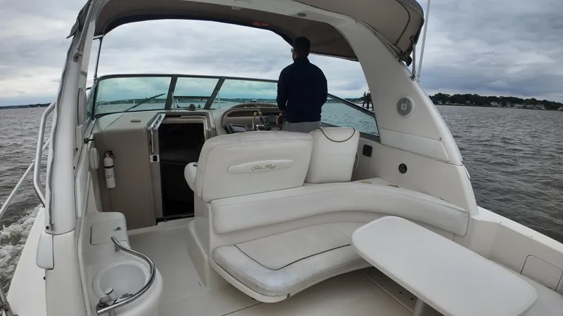 Slide: The Image of 1999 Sea Ray 310 Sundancer boat interior with person steering on open water. - 13