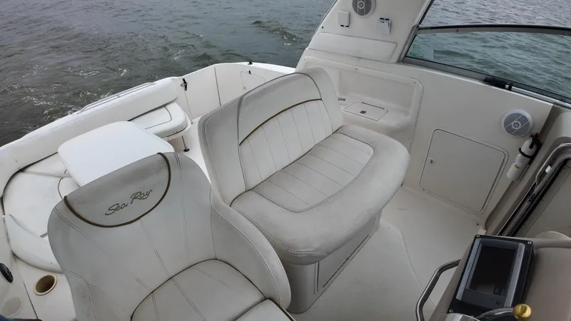 Slide: The Image of 1999 Sea Ray 310 Sundancer boat interior with white seating and water view. - 19