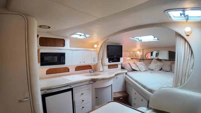 Slide: The Image of 1999 Sea Ray 310 Sundancer cabin interior with kitchenette, bed, and skylights. - 20