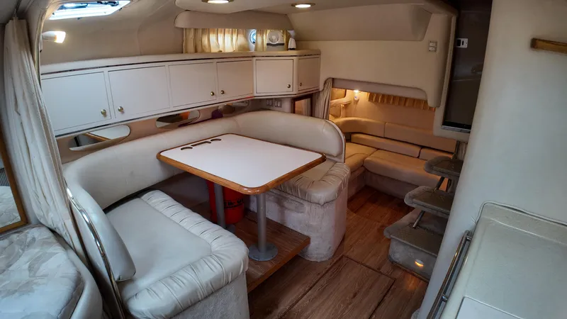 Slide: The Image of Interior of 1999 Sea Ray 310 Sundancer yacht with dining area and seating. - 23