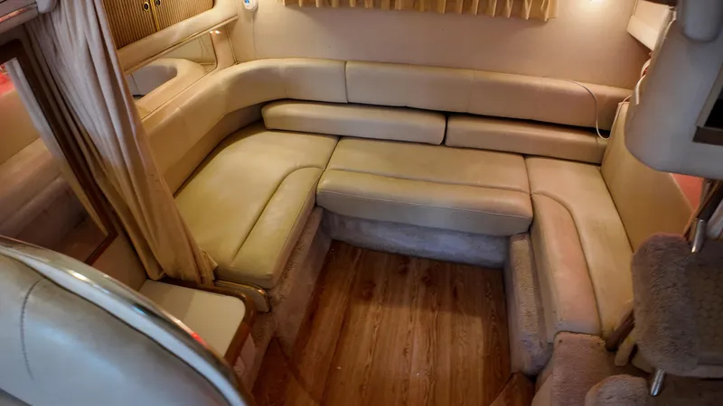 Slide: The Image of Interior of 1999 Sea Ray 310 Sundancer with beige seating and wood flooring. - 25