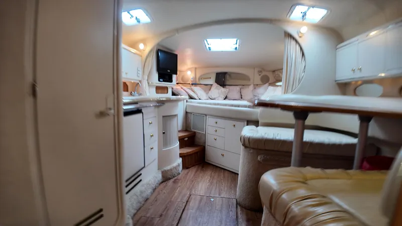 Slide: The Image of Interior of 1999 Sea Ray 310 Sundancer yacht, featuring cozy seating and modern amenities. - 27