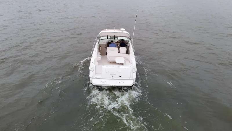 Slide: The Image of 1999 Sea Ray 310 Sundancer cruising on open water, rear view. - 5