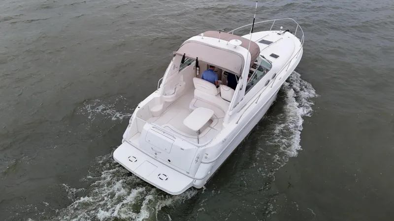 Slide: The Image of 1999 Sea Ray 310 Sundancer cruising on open water, aerial view. - 7