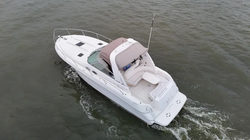 Slide: The Image of 1999 Sea Ray 310 Sundancer cruising on open water, aerial view. - 8