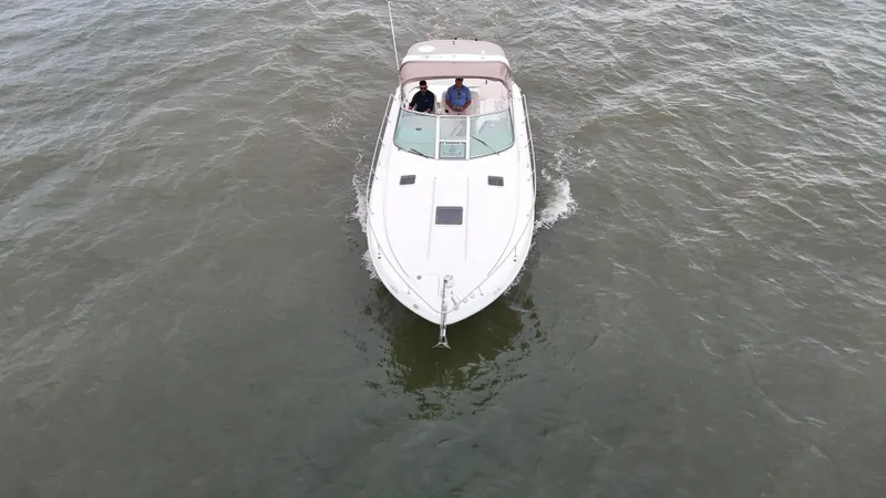 Slide: The Image of 1999 Sea Ray 310 Sundancer cruising on open water, aerial view. - 9