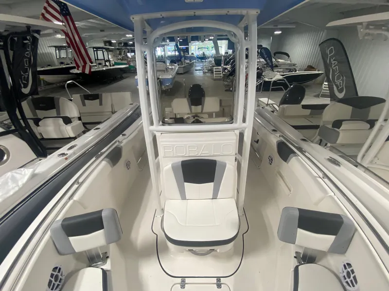 Slide: The Image of 2024 Robalo R222 boat interior with seating and console in showroom. - 12