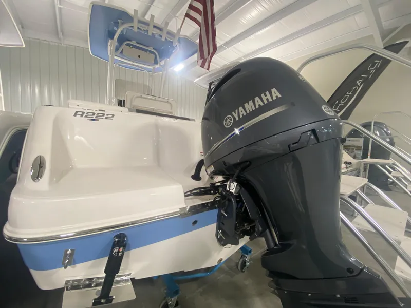 Slide: The Image of 2024 Robalo R222 boat with Yamaha outboard motor in showroom. - 1