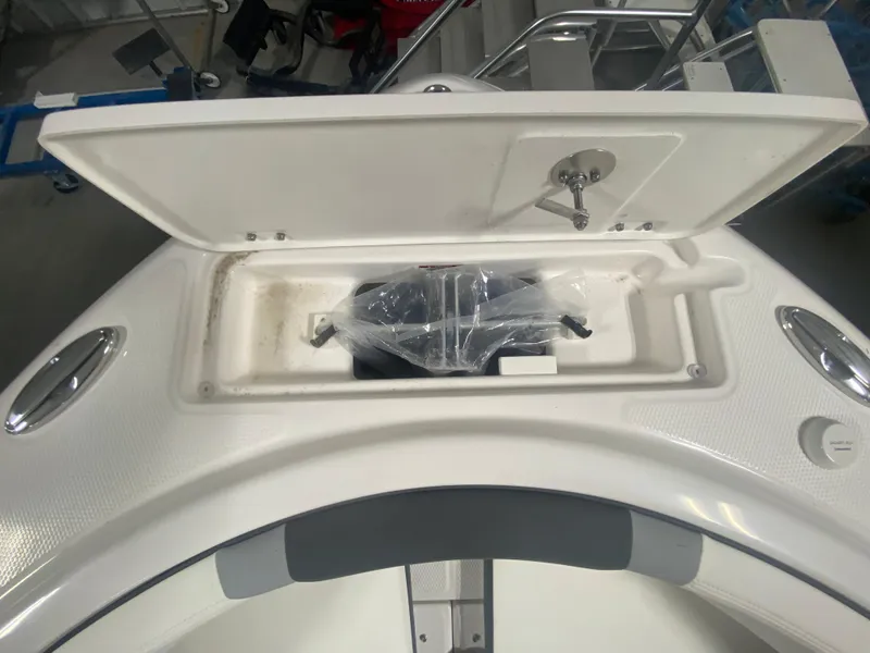 Slide: The Image of 2024 Robalo R222 boat storage compartment with open lid. - 13