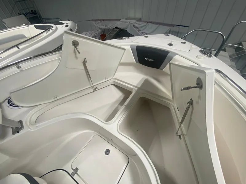 Slide: The Image of 2024 Robalo R222 boat storage compartments open in a clean, white interior. - 15