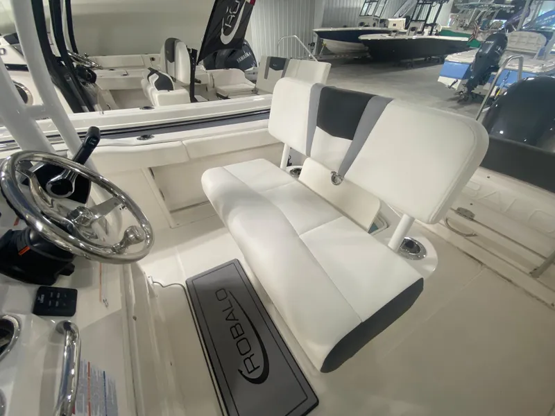 Slide: The Image of 2024 Robalo R222 boat interior with white and gray seating and steering wheel. - 9