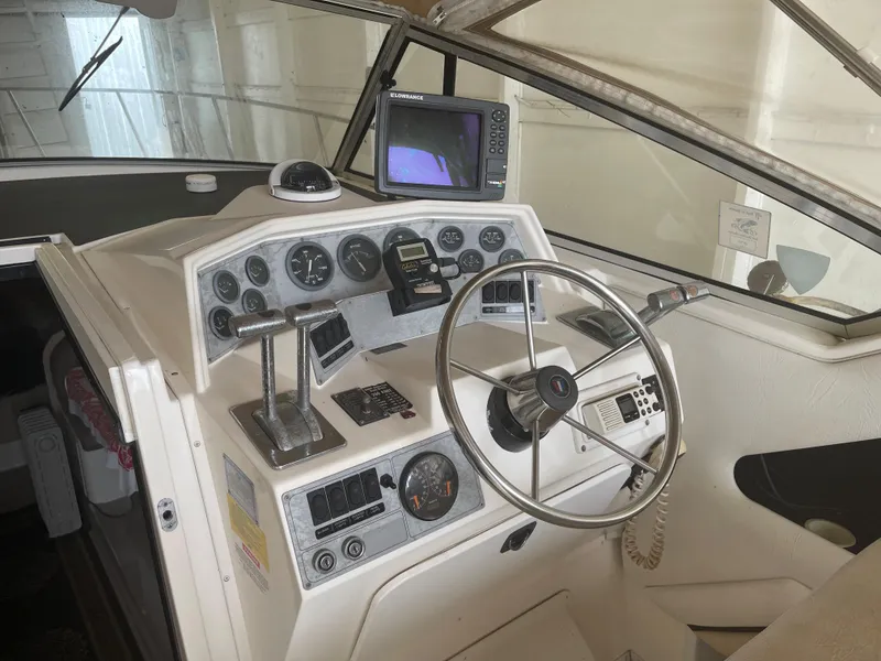 Slide: The Image of 1993 Wellcraft St Tropez 3200 boat helm with steering wheel, gauges, and navigation equipment. - 20