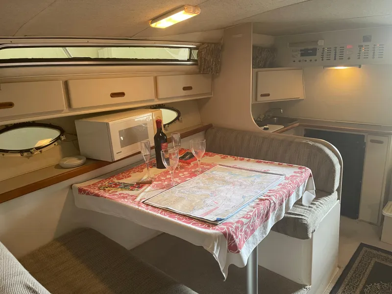 Slide: The Image of 1993 Wellcraft St Tropez 3200 cabin interior with dining area, microwave, and kitchenette. - 22