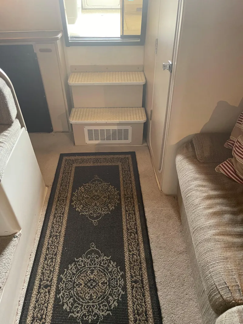 Slide: The Image of Interior of a 1993 Wellcraft St Tropez 3200 boat with carpeted steps and a decorative rug. - 23