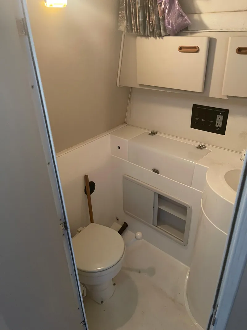Slide: The Image of 1993 Wellcraft St Tropez 3200 boat bathroom with toilet, sink, and storage cabinets. - 24