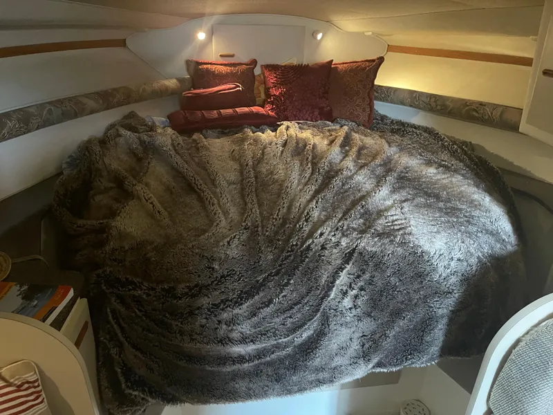 Slide: The Image of Cozy cabin interior of 1993 Wellcraft St Tropez 3200 with plush bedding and pillows. - 25