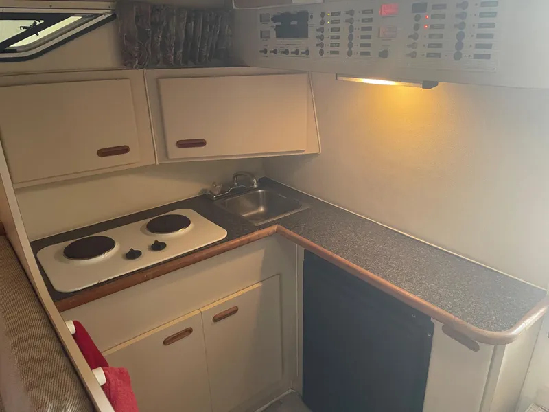Slide: The Image of 1993 Wellcraft St Tropez 3200 boat kitchen with stove, sink, and cabinets. - 30