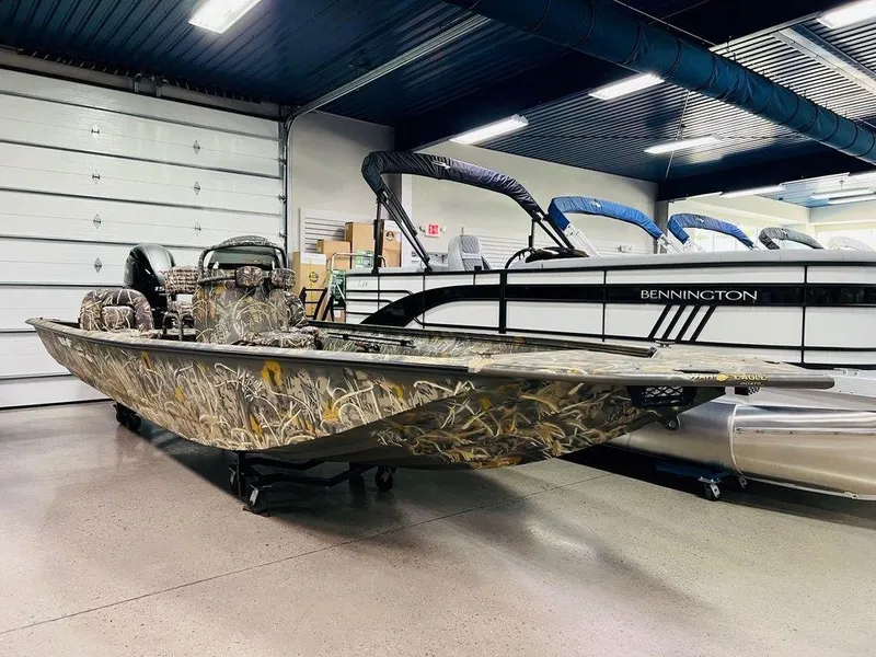 Slide: The Image of 2025 War Eagle Blackhawk 2170 boat with camouflage design in a showroom. - 1