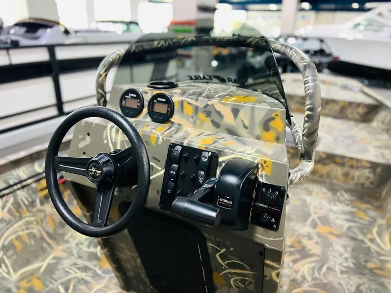Slide: The Image of 2025 War Eagle Blackhawk 2170 boat interior with camo design and steering console. - 2