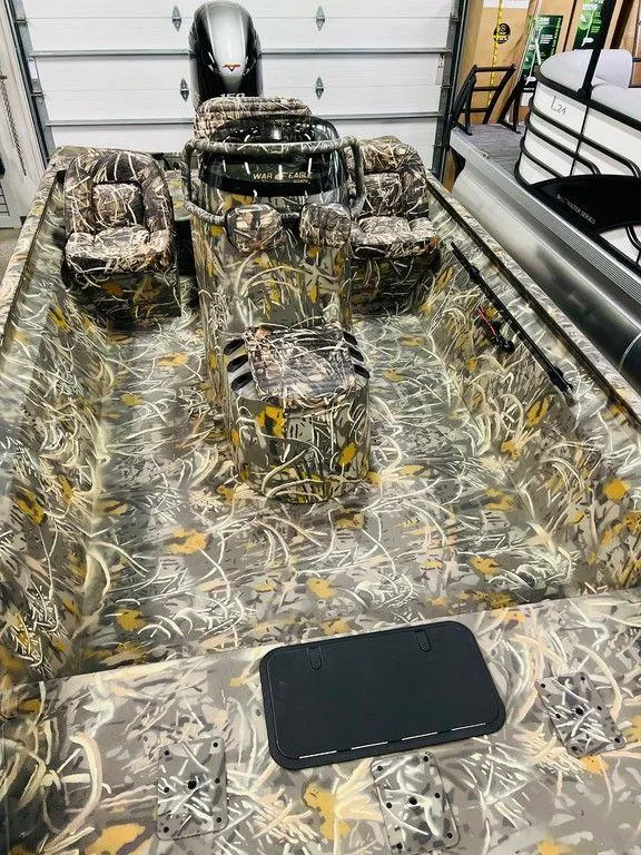 Slide: The Image of 2025 War Eagle Blackhawk 2170 boat with camouflage design in a garage setting. - 4