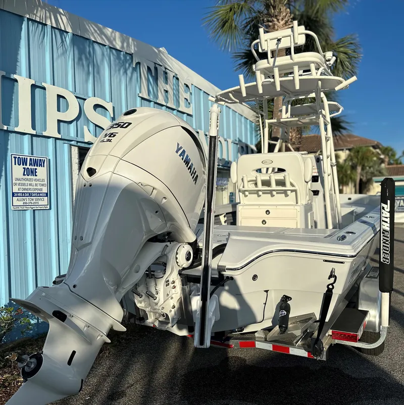 Slide: The Image of 2025 Pathfinder 2600 TRS boat with Yamaha engine, docked near a blue building. - 19