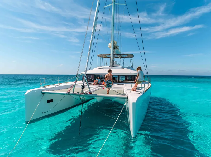 Slide: The Image of 2020 Lagoon 52 F catamaran sailing on clear turquoise waters under a bright blue sky. - 10