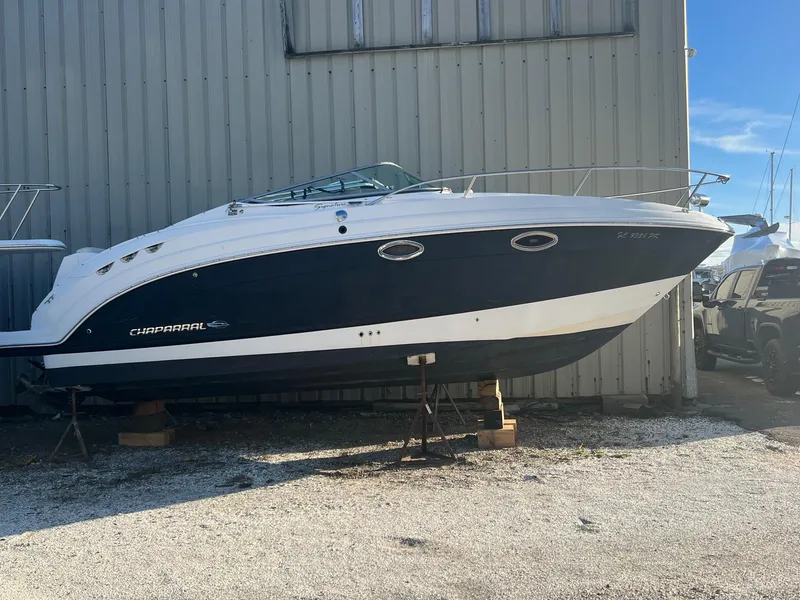 The Image of 2008 Chaparral Signature 250 boat on stands, parked outdoors near a building. - 0