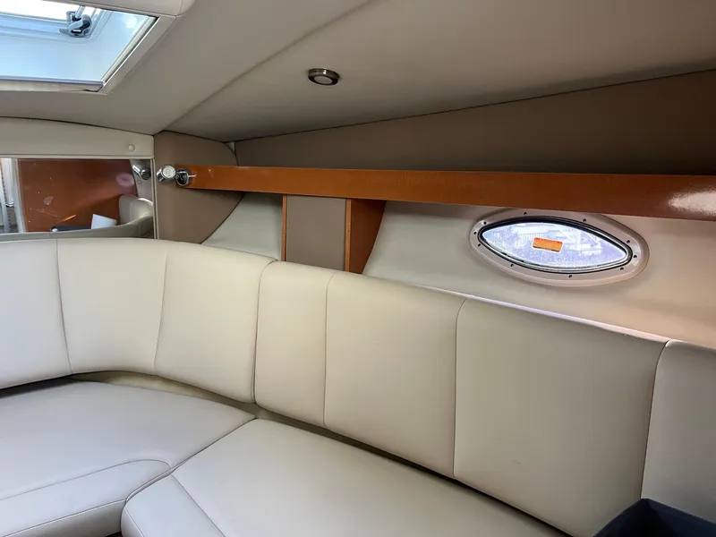 Slide: The Image of 2008 Chaparral Signature 250 cabin interior with beige seating and porthole window. - 7