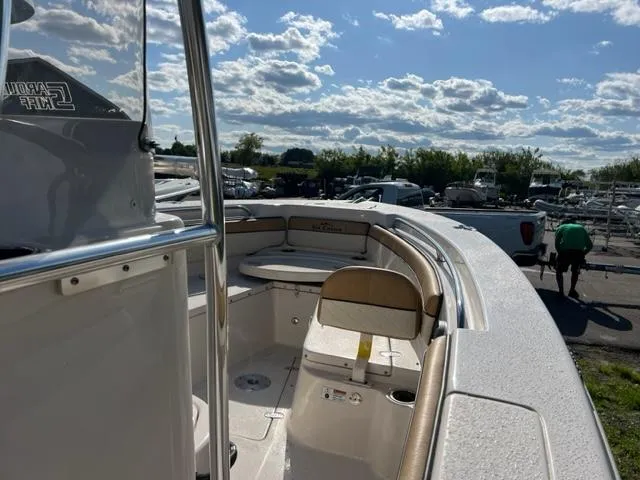 Slide: The Image of 2023 Sea Chaser 22 HFC boat interior with seating and console, parked outdoors. - 4