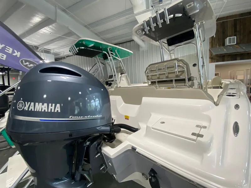 Slide: The Image of 2024 Key West 219 FS boat with Yamaha outboard motor in showroom. - 2