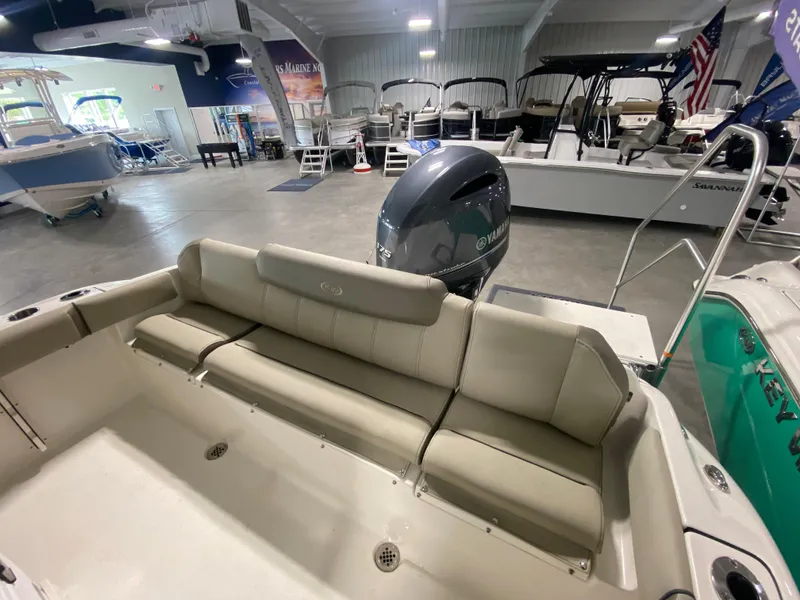 Slide: The Image of 2024 Key West 219 FS boat interior with seating and outboard motor in showroom. - 4