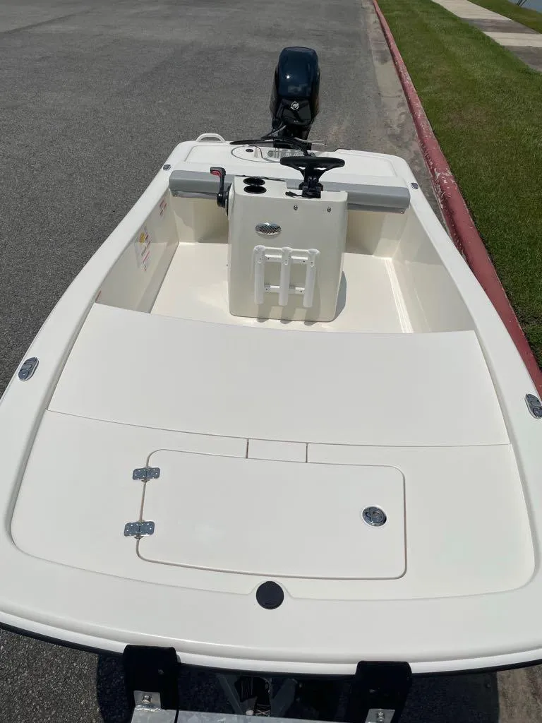 Slide: The Image of 2023 Mako Pro Skiff 13 CC boat with outboard motor on a paved surface. - 3