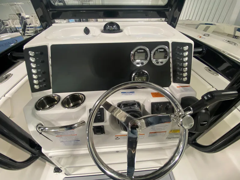Slide: The Image of 2024 Robalo 246 Cayman boat dashboard with steering wheel and control panel. - 10