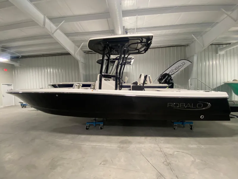 Slide: The Image of 2024 Robalo 246 Cayman boat in a showroom, side view. - 0