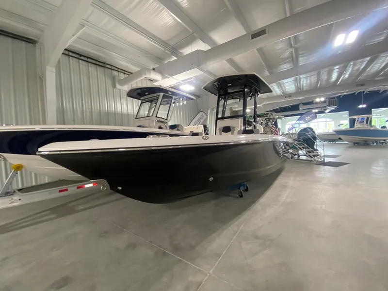 Slide: The Image of 2024 Robalo 246 Cayman boat displayed in a showroom. - 1