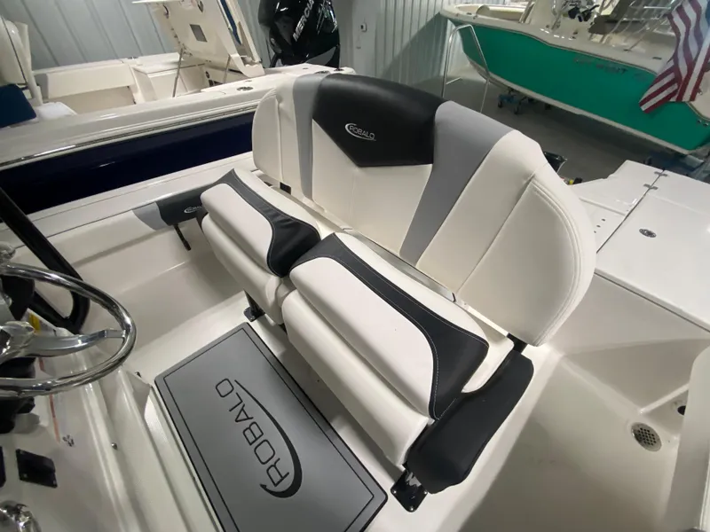 Slide: The Image of 2024 Robalo 246 Cayman boat interior with cushioned seating and steering wheel. - 8