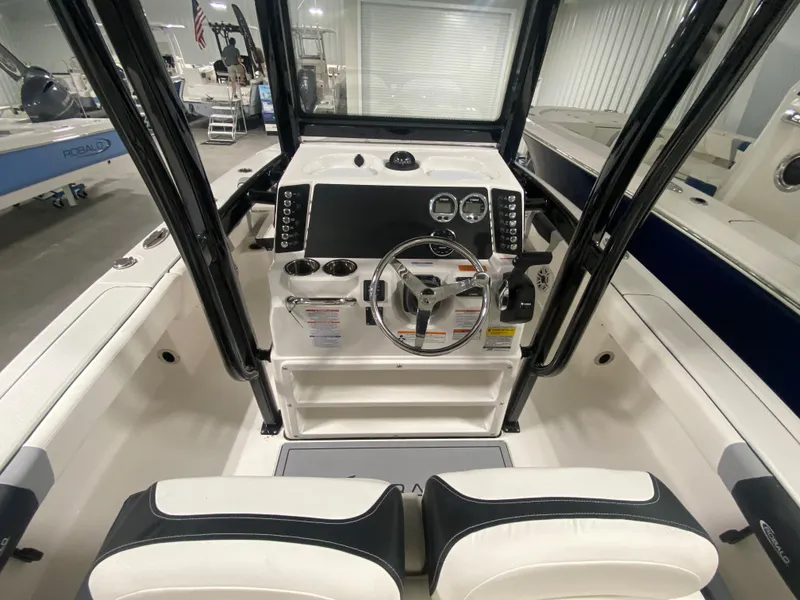 Slide: The Image of 2024 Robalo 246 Cayman boat console and seating area in showroom. - 7