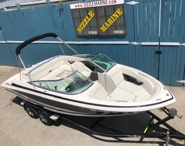 Slide: The Image of 2004 Regal 2200 Bowrider boat on trailer in front of blue fence. - 5